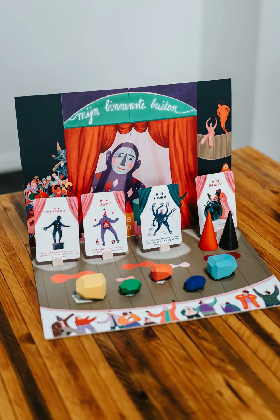 De volledige toolkit opgebouwd als theaterset met spelerskaarten, houten tools en opstellingsbord
